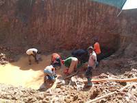 Ugandan miners panning and searching for gold