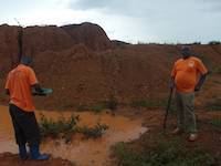 Boys are gold panning on the open pit