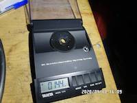 0.144 grams of natual gold particles on the balance scale