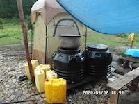 2020-05-02: Water tanks used as storage for food and shower tent in background