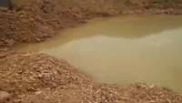 Small pond for processing gold containing ores in Akwatia, Ghana