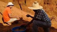 Mr. Louis advising the mining site owner about gold panning methods