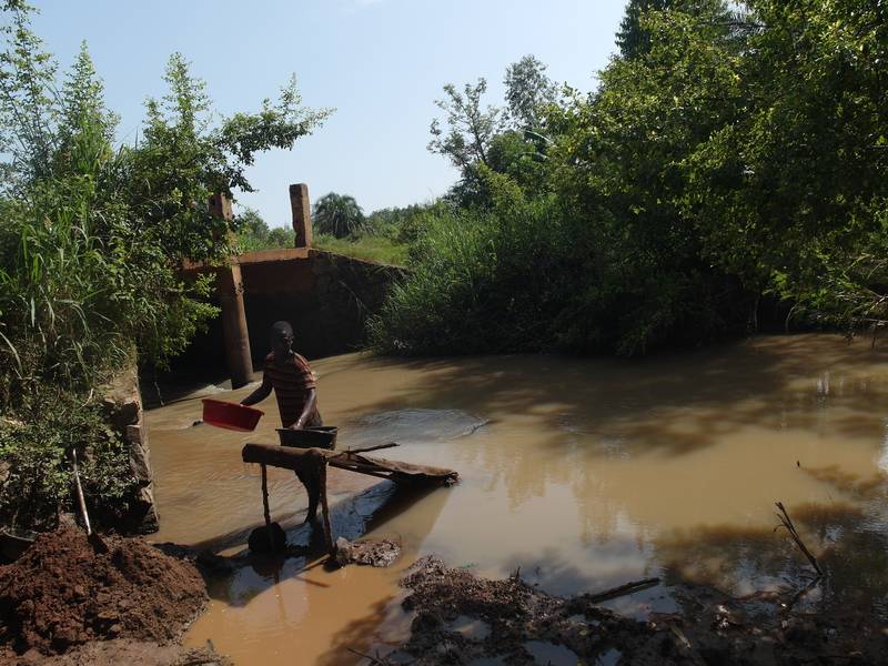 Person processing soil on the river Okame