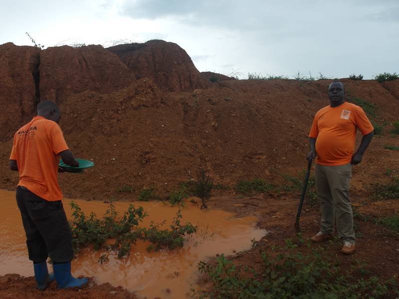 Boys are gold panning on the open pit