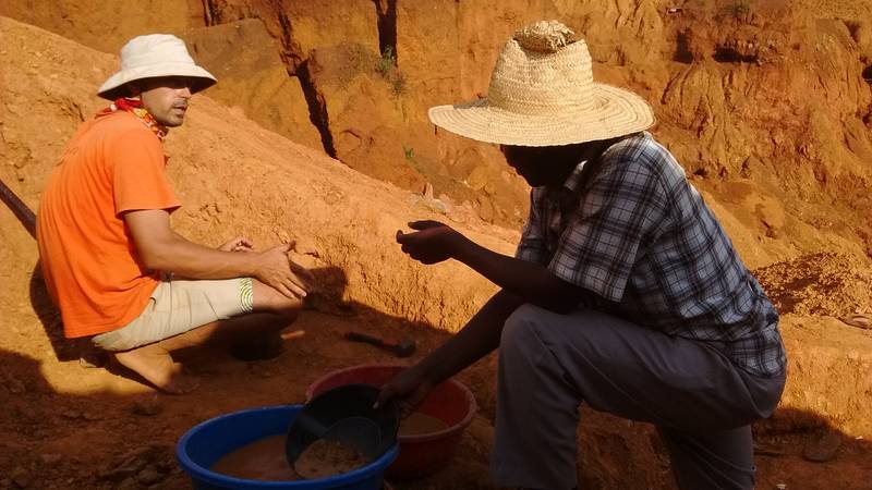 Mr. Louis advising the mining site owner about gold panning methods