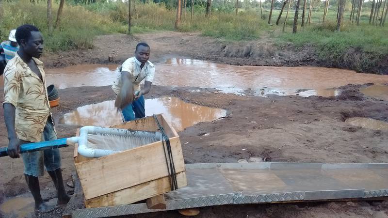 Miners shoveling sand into the sluice