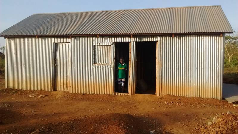 Goldivanti LP purchasing manager in Uganda in front of the storage room