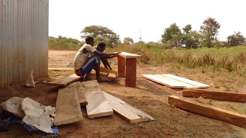 Workers preparing bench and desks as open-air furniture