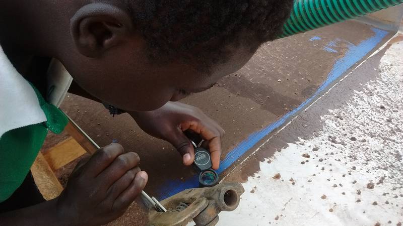 Purchasing manager verifying gold particles on the sluice